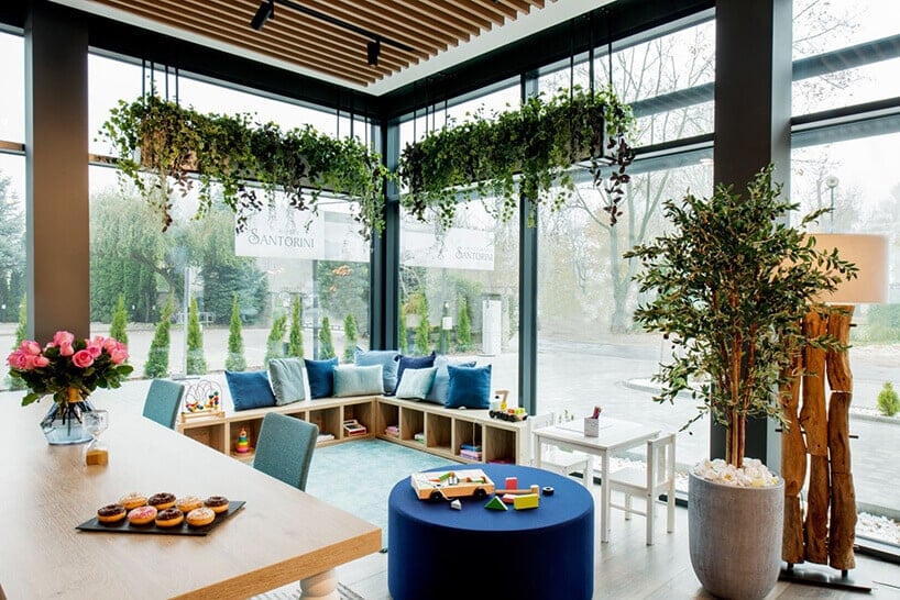 ibis Styles Santorini hotelowa restauracja stoliki przy oknie z kwiatami na wiszącej doniczce