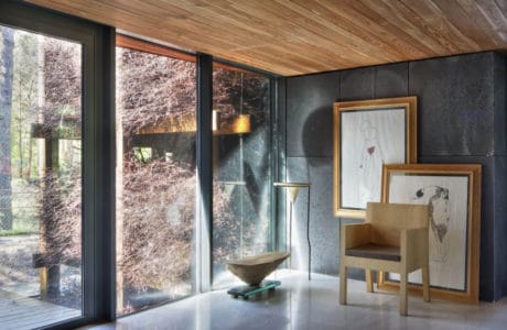 salon z drewnianym dachem z przeszkleniem oraz obrazami w drewnianych ramach