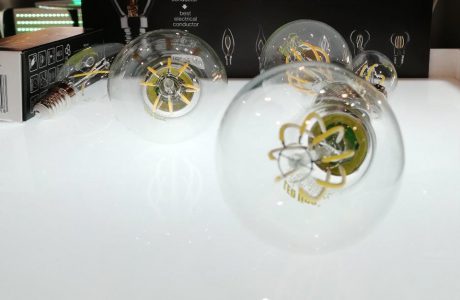 trzy żarówki LED leżące na białym podświetlonym blacie