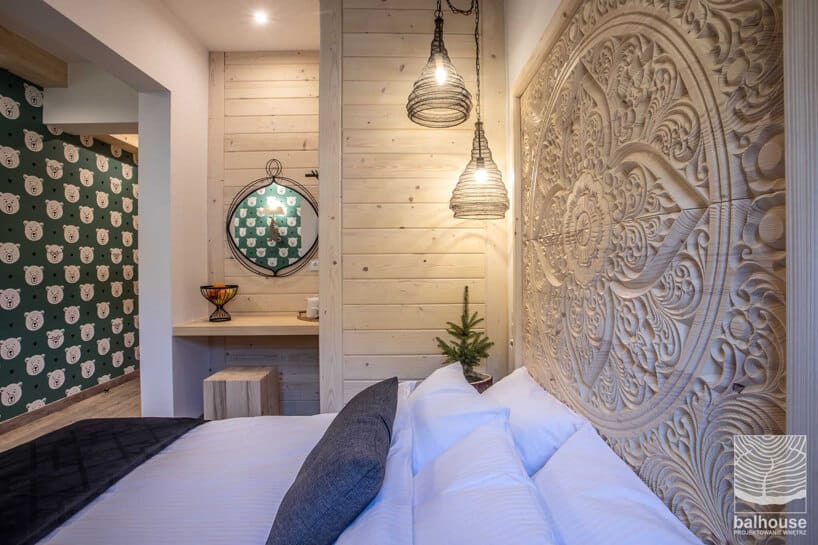 pokój hotelowy z drewnianymi zdobieniami na ścianie w Niedźwiedzia Residence