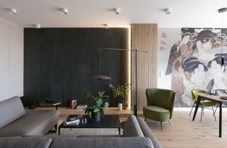 salon w stylu japońskim z ciemno szarą rogówką oraz czarnymi panelami na fragmencie ściany