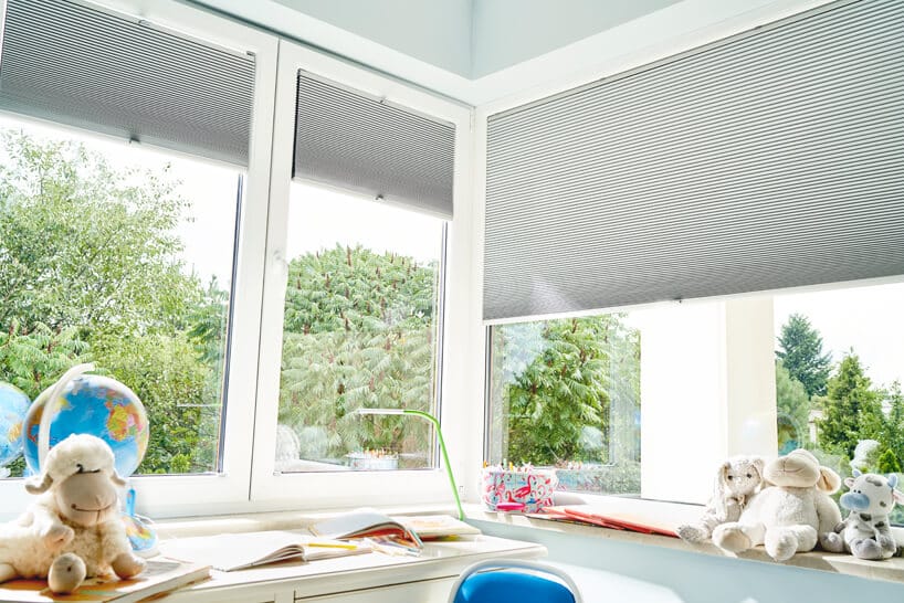 nowoczesne plisowane szare żaluzje okienne od ANWIS w jasnym pokoju dziecięcym