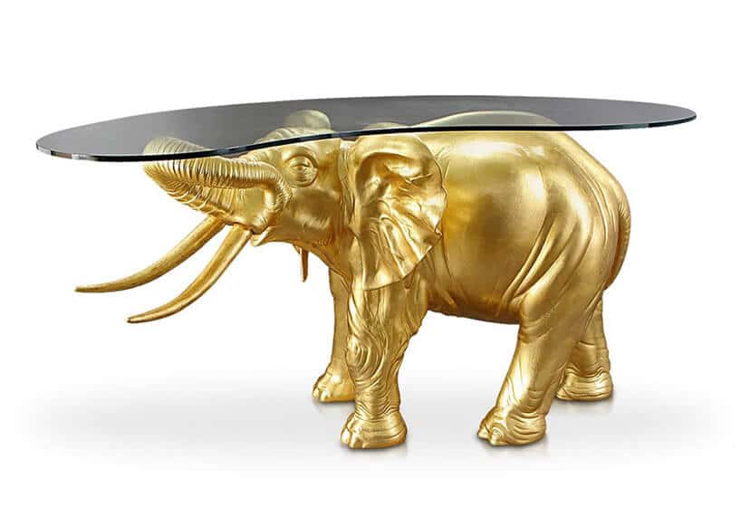 złoty słoń podtrzymujący szklany blat stolika